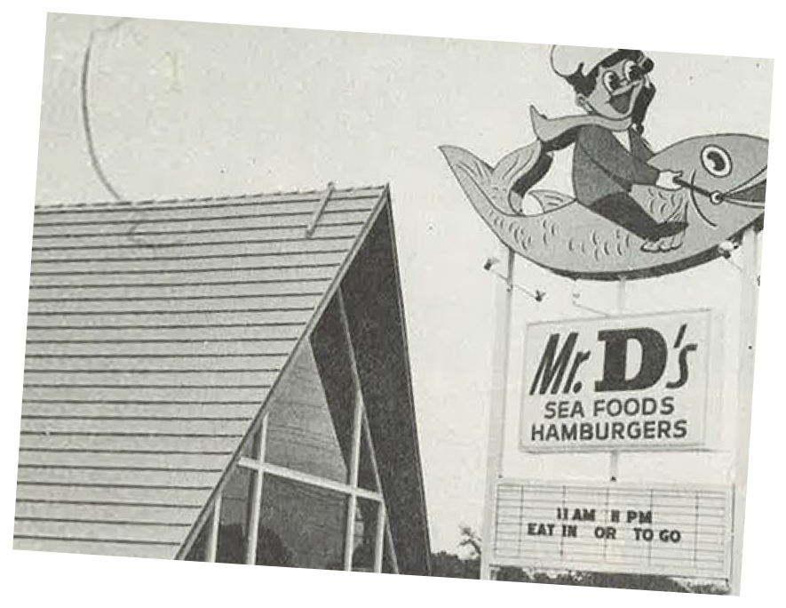 Image of the first Mr. D's Seafood and Hamburgers store and sign, featuring a cartoon of a kid riding a fish.