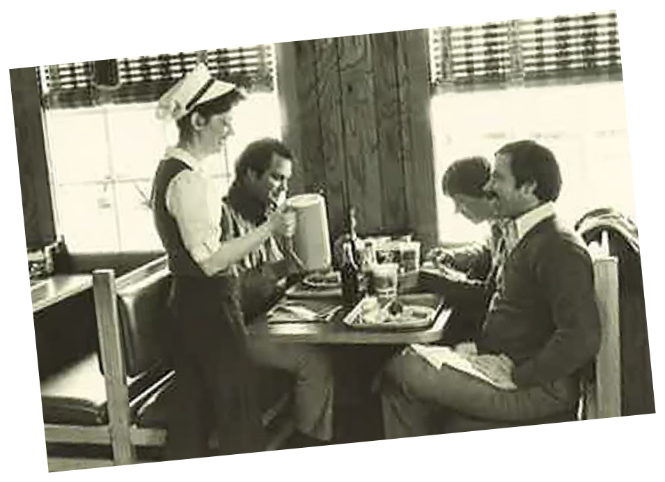 Image of a waitress serving beverages to a table of Captain D's customers.